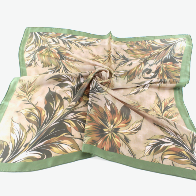 meredith Cream square scarf with a flowing botanical print in green, ochre, neutrals, framed by a green border.