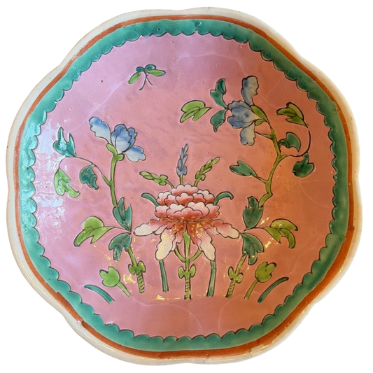 Decorative ceramic plate with floral design on a pink background