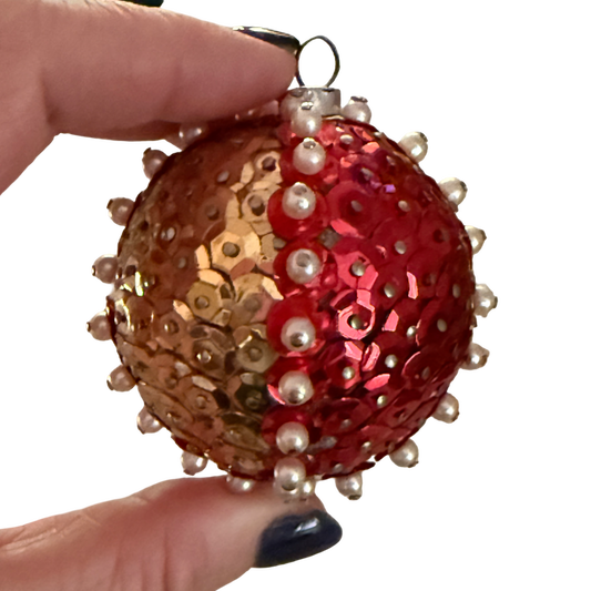 Vintage ball ornament with alternating red and gold-tone sequin panels, raised pearl-look bead borders, and a metal hanging loop.